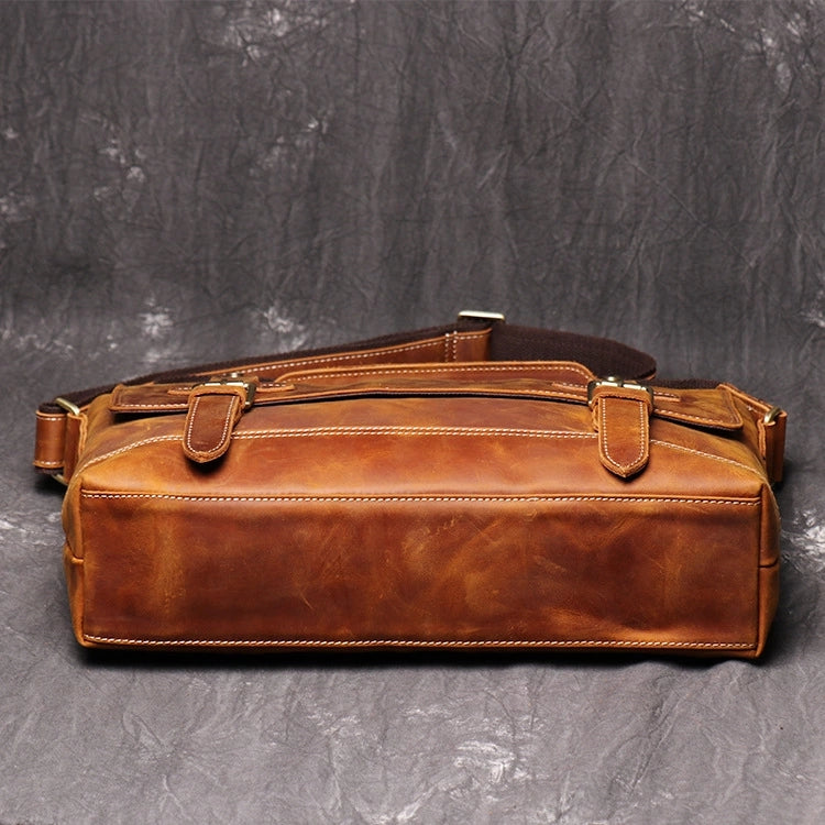 Bottom view of brown leather messenger bag showing stitching detail and material