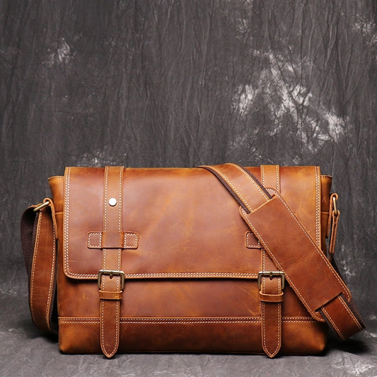 Front view of brown leather messenger bag showing stitching detail and shoulder strap