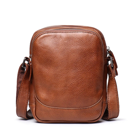 Front view of brown leather sling bag showing stitching detail and material texture