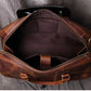 Top view of brown leather duffel bag with open zipper showing inside