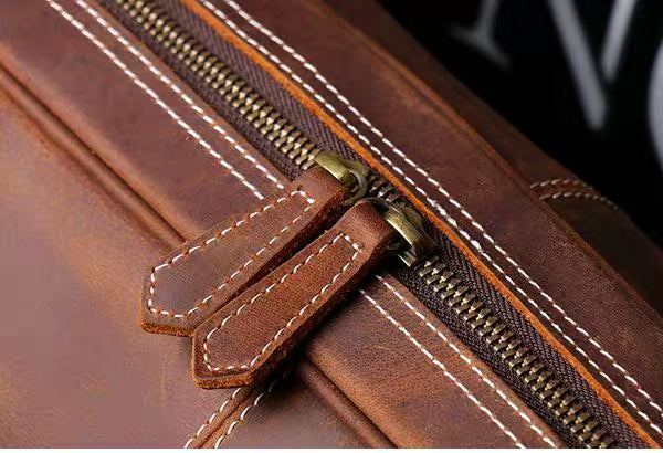 Top closeup view of brown leather duffel bag showing the zipper