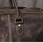 Closeup view of dark coffee color leather duffel bag showing stitching detail handle strap and metal