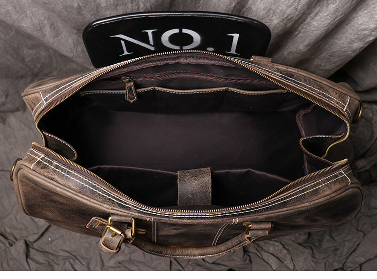 Top view of dark coffee color leather duffel bag showing open zipper and inside details