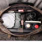 Top view of dark coffee color leather duffel bag showing open zipper and storage capacity